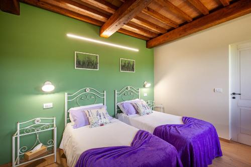 two beds in a room with green walls at Agriturismo Marinello in Pienza