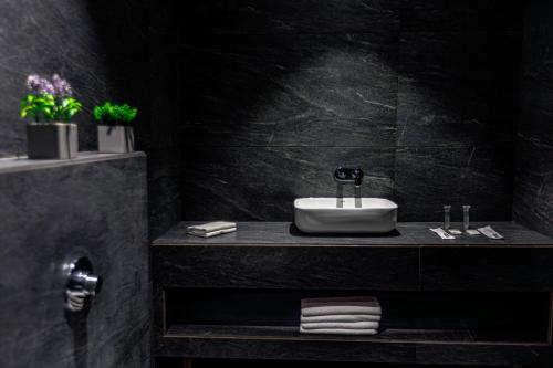 a bathroom with a sink and a black wall at The Democracy Hotel & Resorts Convention Center in Nashik