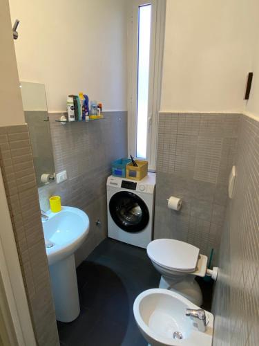 a bathroom with a toilet and a washing machine at Il Limone A San Pietro - Vatican in Rome