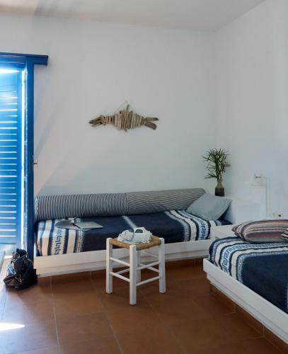 a bedroom with two beds and a table in it at White Blue Villa formerly Ippocampi in Koutouloufari