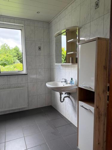 a bathroom with a sink and a mirror at Zimmer im Erdgeschoß mit Bad und Küche in Minden