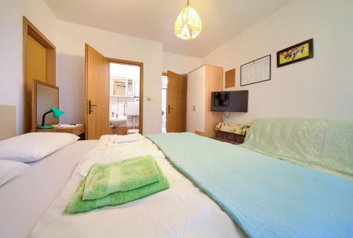 a bedroom with two beds and a flat screen tv at Apartments Jurina 2 in Krk