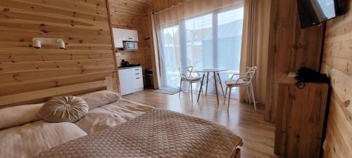 ein Schlafzimmer mit einem Bett und einem Tisch mit Stühlen in der Unterkunft Gemini MiniDomki in Ustka