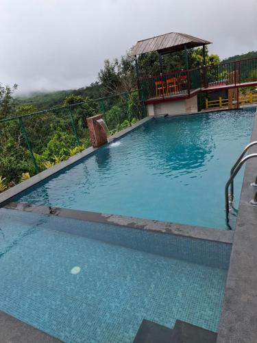 a large blue swimming pool with a gazebo at Merjin's Paraiso in Vagamon