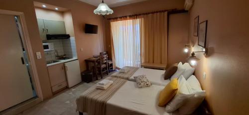 ein Schlafzimmer mit einem großen weißen Bett und gelben Kissen in der Unterkunft Villa Manolis in Tolo