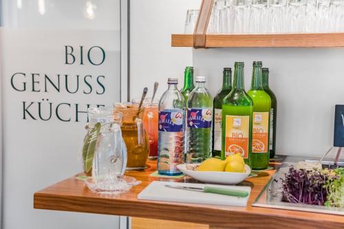 a counter with bottles of alcohol and vegetables on it at Villa Ceconi by Das Grüne Hotel zur Post - 100% BIO in Salzburg