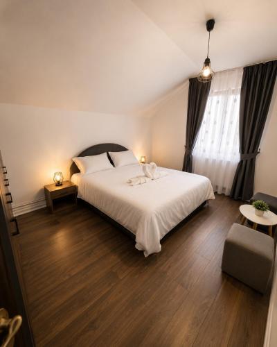 a bedroom with a large white bed and a window at Casa Casy in Oradea