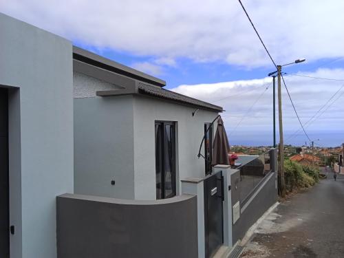 a white building with a fence next to a street at Cottagee Grandpa Silva in Santana