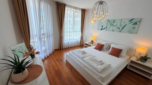 a bedroom with a white bed and a chandelier at Бяла Виста Клиф - Byala Vista Cliff in Byala