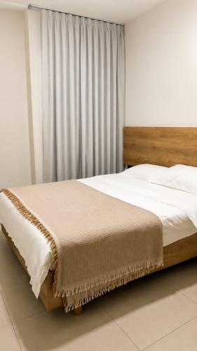 a bed with a wooden headboard in a bedroom at Spacious 2-Bedroom Family Suite with Pool & Garden View in Moka