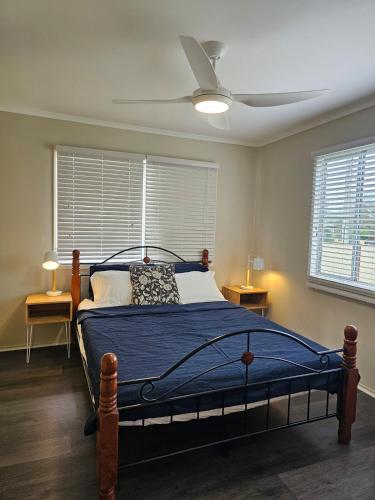 a bedroom with a bed and a ceiling fan at The Pine Rest - Spacious & Central Haven in Brendale