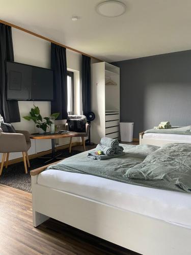 ein Schlafzimmer mit zwei Betten und ein Wohnzimmer in der Unterkunft Design Quartier 6 Family&Business in Neunkirchen