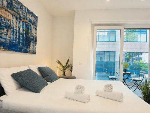 a white bedroom with a large white bed with two pillows at Emerald Apartment City Center in Lugano