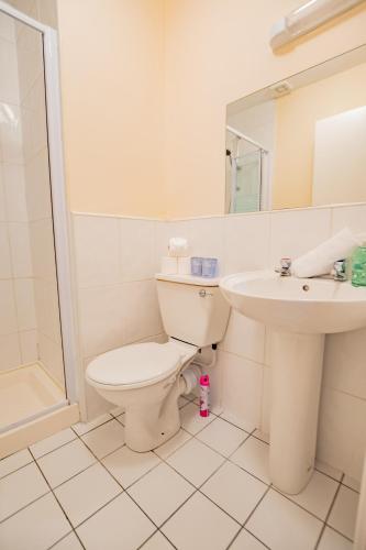 a white bathroom with a toilet and a sink at Spacious Group Base - 4 Bed Central Limerick in Limerick