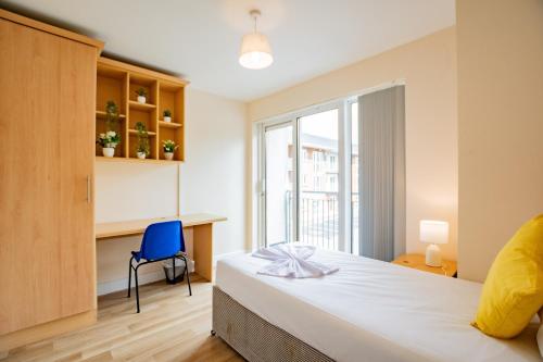 a bedroom with a bed and a blue chair at Spacious Group Base - 4 Bed Central Limerick in Limerick