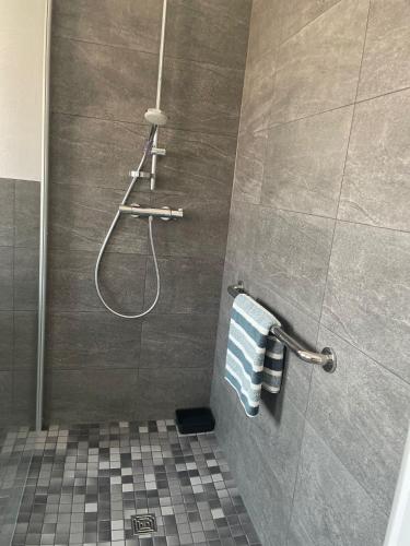 ein Badezimmer mit Dusche und blau-weißen Handtüchern in der Unterkunft Design Quartier 6 Family&Business in Neunkirchen