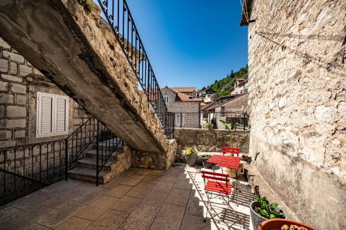 a stone alley with red chairs and stairs next to a building at Serenity Sea in Perast