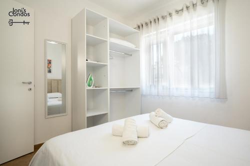a white bedroom with towels on a white bed at Joni's Condo 10 in Golem