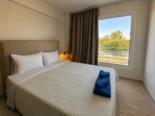 a bedroom with a bed with a blue bow tie on it at Bliss Getaway Near Protaras in Paralimni