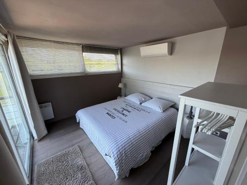 a small bedroom with a bed and a desk at Maison bord de Seine à 20 min de Paris in Villennes-sur-Seine