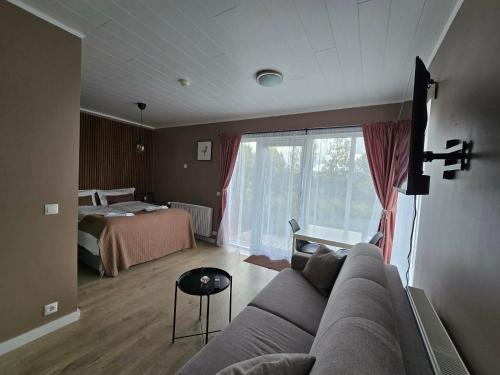 a living room with a couch and a bed at Romantic Cottage in Fludir