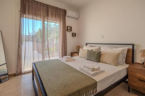 a bedroom with a large bed and a large window at San House 1 in Archangelos