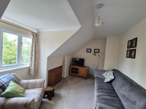 a living room with a couch and a tv at Quiet Annexe in Oundle in Oundle