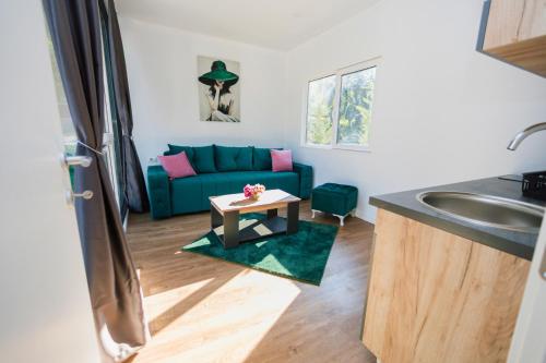 a living room with a blue couch and a table at EloA Glamping in Petrovac na Moru