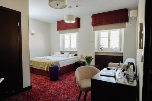 a hotel room with a bed and a desk at B&B Wieniawa in Leszno