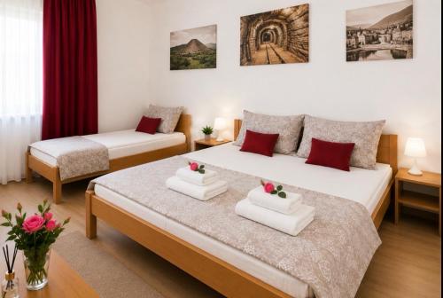 a hotel room with two beds and red curtains at Becar Pyramids B&B in Visoko