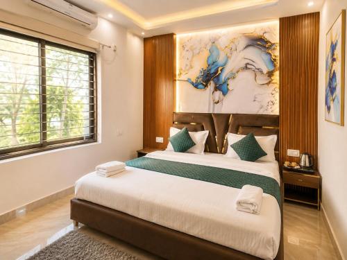 a bedroom with two beds and a painting on the wall at The Hotel Atlantis Suites Sigra Road Near Vishwanath Temple in Varanasi