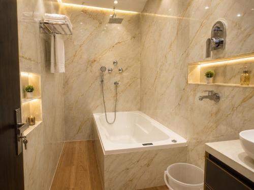 a bathroom with a tub and a sink at The Hotel Atlantis Suites Sigra Road Near Vishwanath Temple in Varanasi