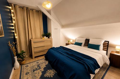a bedroom with a large bed with blue sheets at Le Cercle des Éléments - Maison d'exception - Cinéma, Parking privé -Classé 4 étoiles in La Rivière-de-Corps