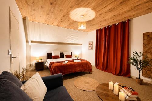 a hotel room with a bed and a couch at Le Cercle des Éléments - Maison d'exception - Cinéma, Parking privé -Classé 4 étoiles in La Rivière-de-Corps