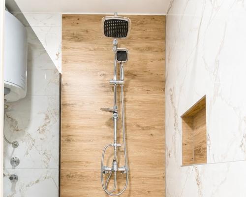 a shower with a shower head in a bathroom at Teslić CITY Apartment in Teslić