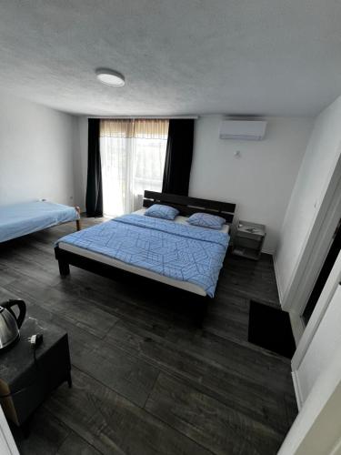 a bedroom with a bed with a blue comforter at Apartman UnaTesnim in Bihać