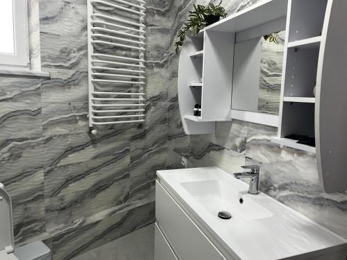 a bathroom with a sink and a marble wall at Готель Сузірʼя in Kolomiya