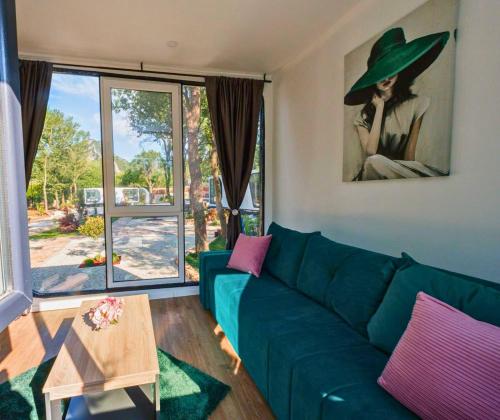 a living room with a green couch and a table at EloA Glamping in Petrovac na Moru