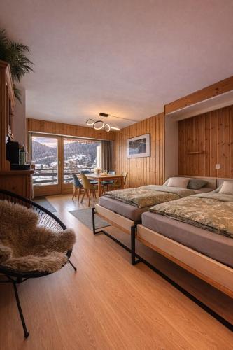 a bedroom with two beds and a table and chairs at Vue Alpes imprenable - Centre - 4 Vallées in Nendaz