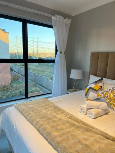 a bedroom with a bed and a large window at Luxury Apartment - Breathtaking River Views in Kyalami