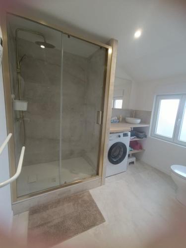 a glass shower in a bathroom with a toilet at La parenthèse Audomaroise in Heuringhem