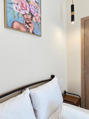 a bedroom with a bed with a painting on the wall at evelinas view 3 in Mytilene