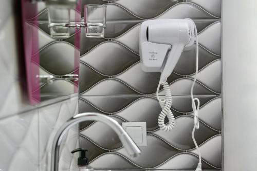 a bathroom with a sink and a hair dryer at Hotel Heimli in Prishtinë