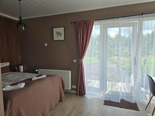 a bedroom with a bed and a large window at Romantic Getaway in Fludir