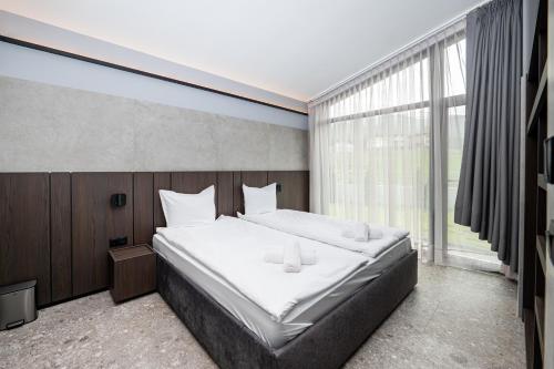 a bedroom with a large bed and a large window at Chalet Rila in Govedartsi
