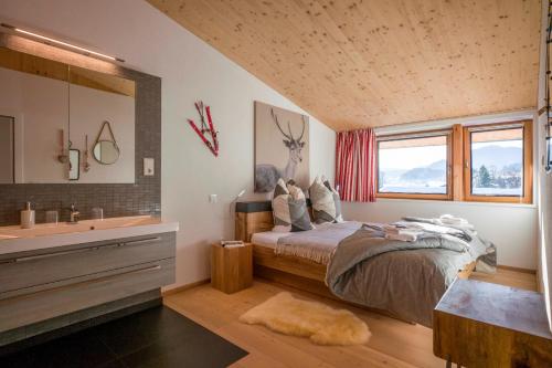 ein Schlafzimmer mit einem Bett und ein Badezimmer mit einer Badewanne in der Unterkunft "sunnseit" Appartement in Söll