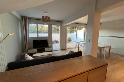 a living room with a couch and a tv at Maison proche grande plage in Quiberon