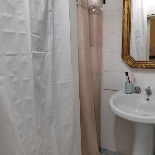 a bathroom with a shower curtain and a sink at Siciliana in Caronia