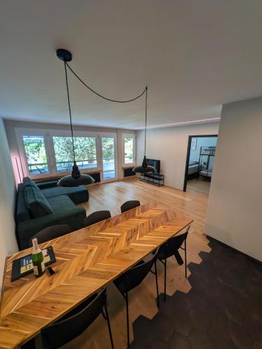 a living room with a wooden table and a couch at Ferienwohnung Flumserberg, Liftnähe & Gratis Parkplatz in Flumserberg