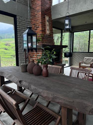 a large wooden table with chairs and a fireplace at Misty mountains residents in Huluganga